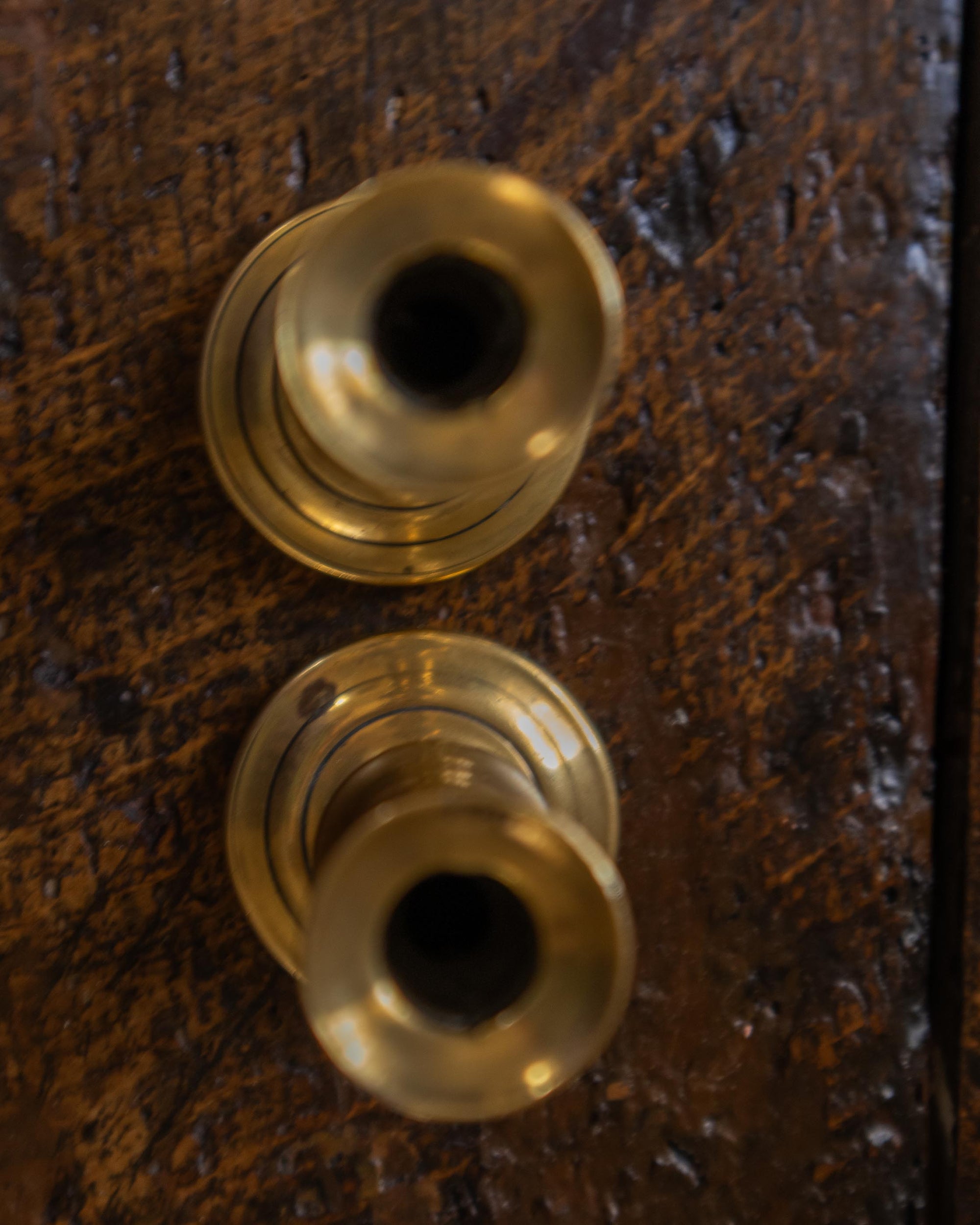 Brass tapersticks on a wooden surface