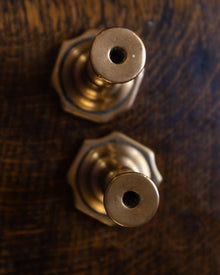 Brass tapersticks on a wooden surface