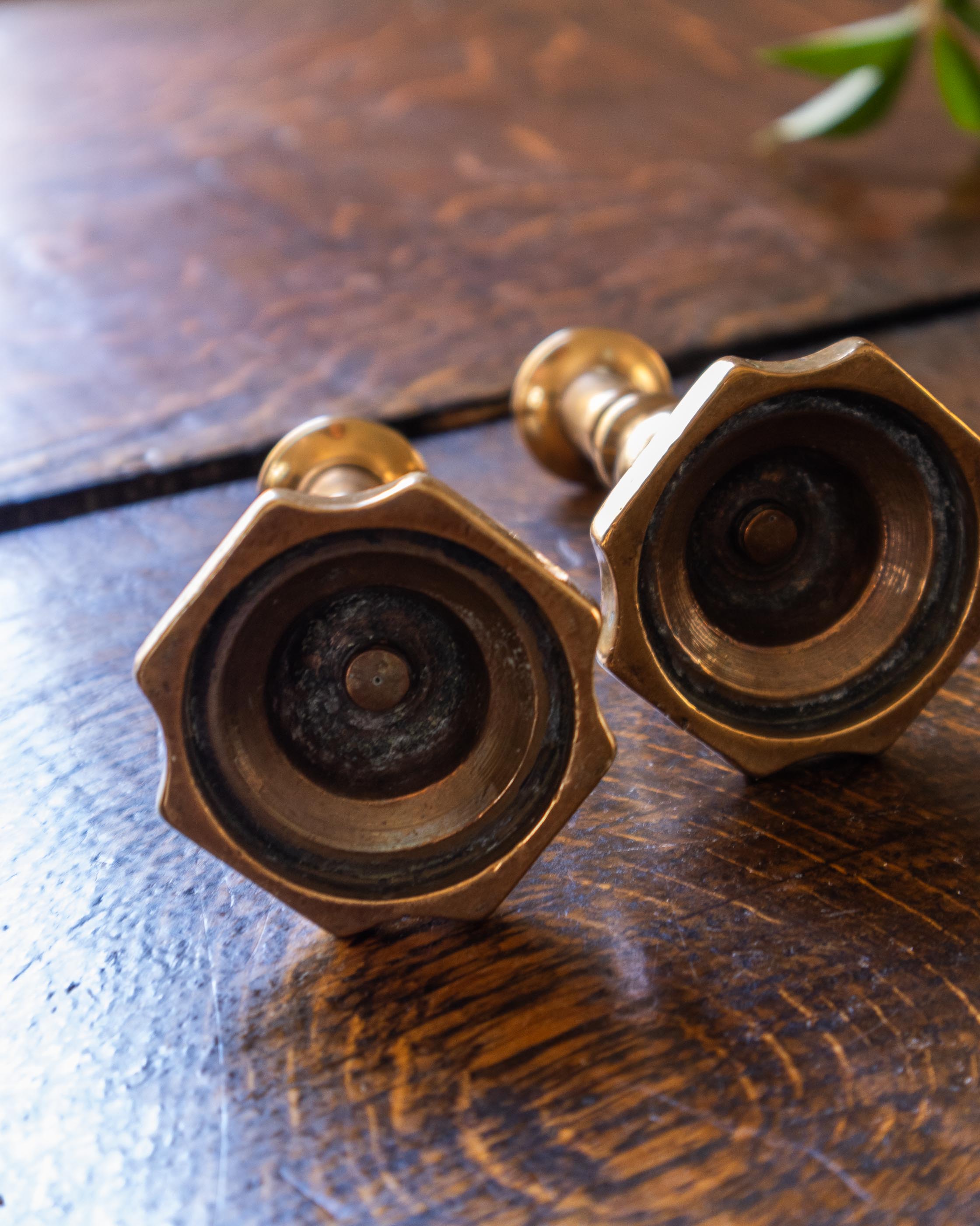 Brass tapersticks on a wooden surface