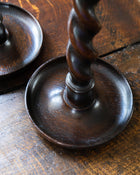 Wooden candlestick with twisted design on a wooden surface