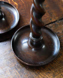 Wooden candlestick with twisted design on a wooden surface