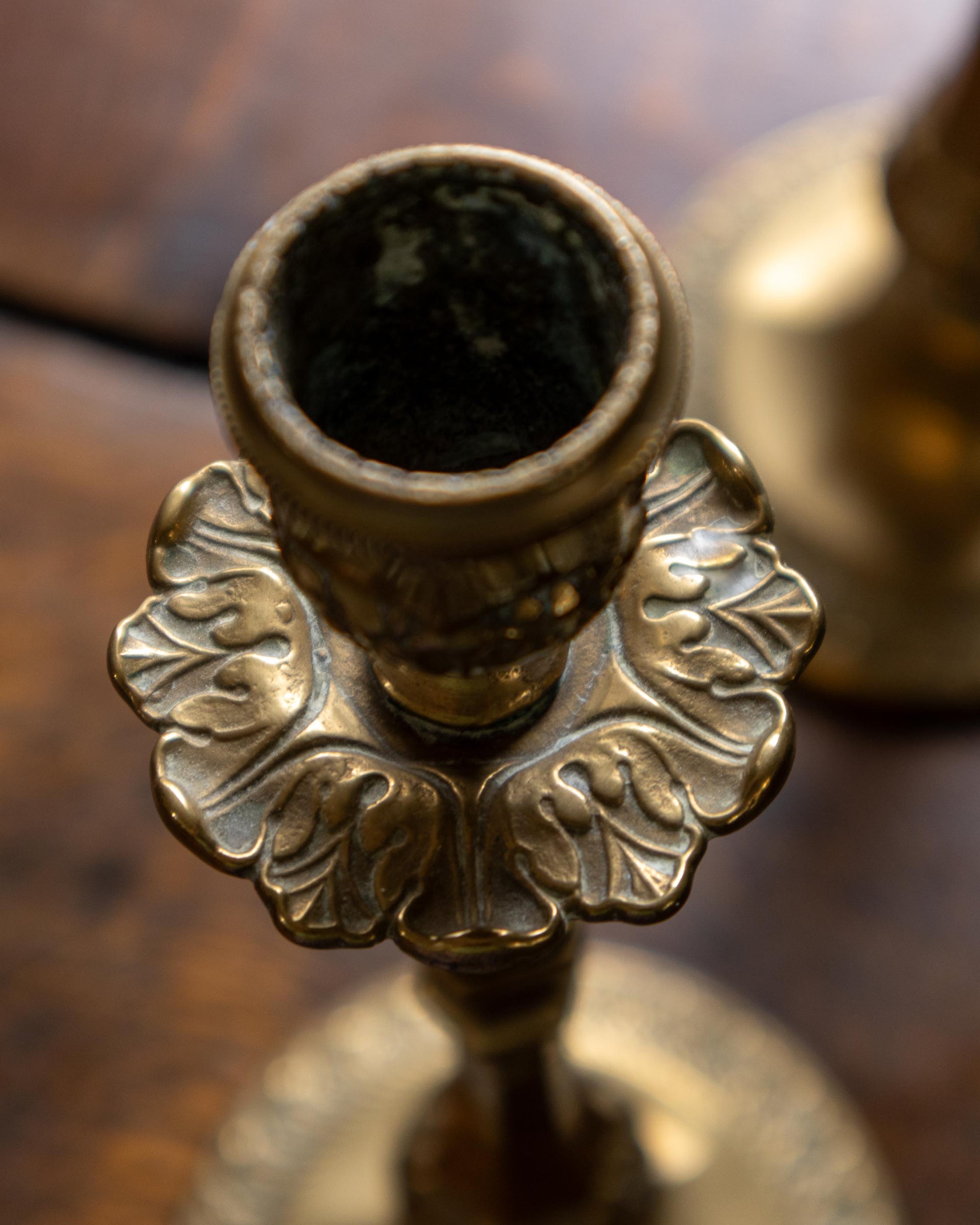 Close-up of a decorative brass candle holder on a wooden surface.
