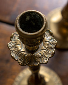 Close-up of a decorative brass candle holder on a wooden surface.