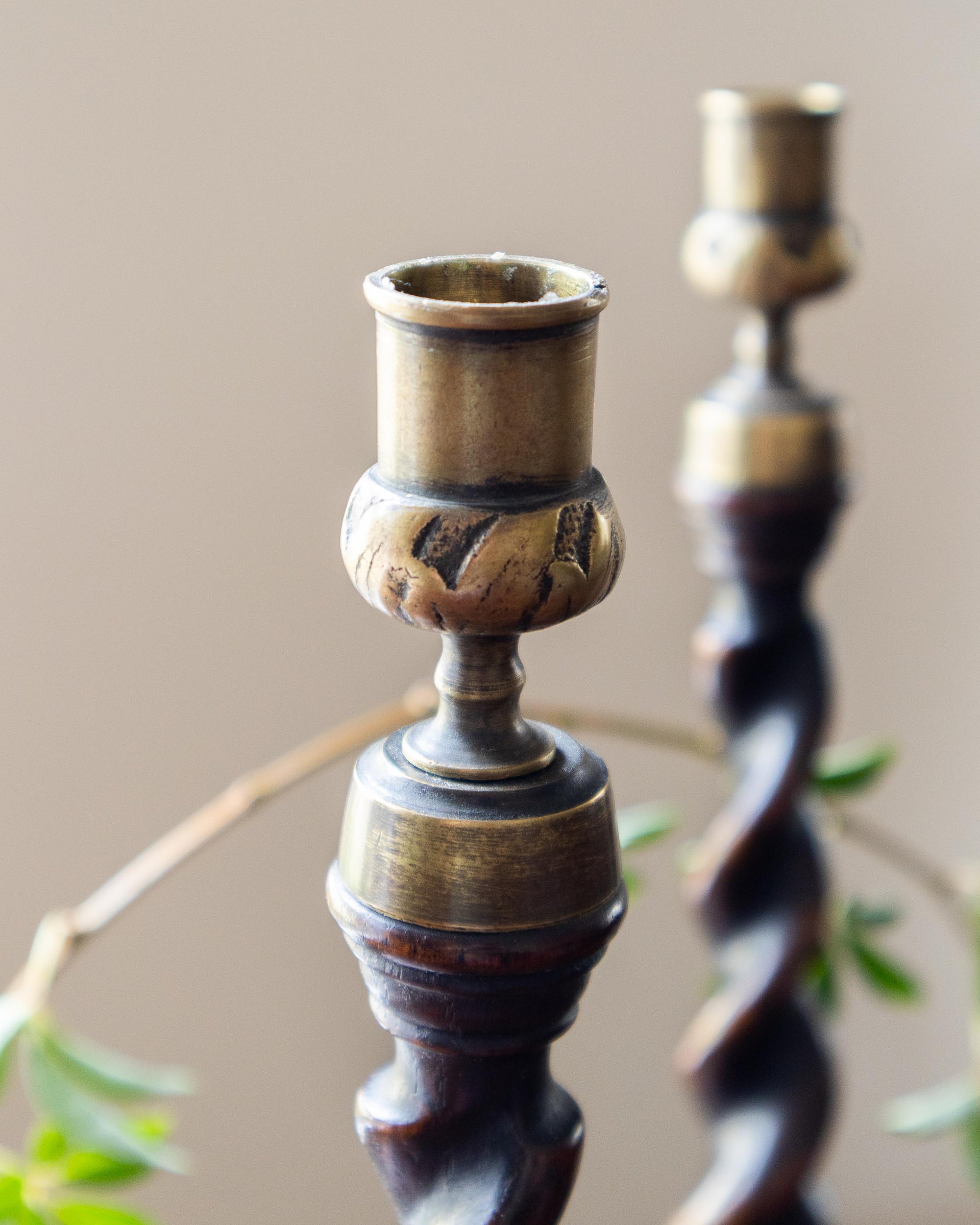 Pair of decorative candle holders with a rustic design on a neutral background
