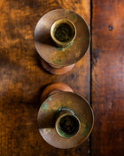 Two oak candle holders on a wooden surface