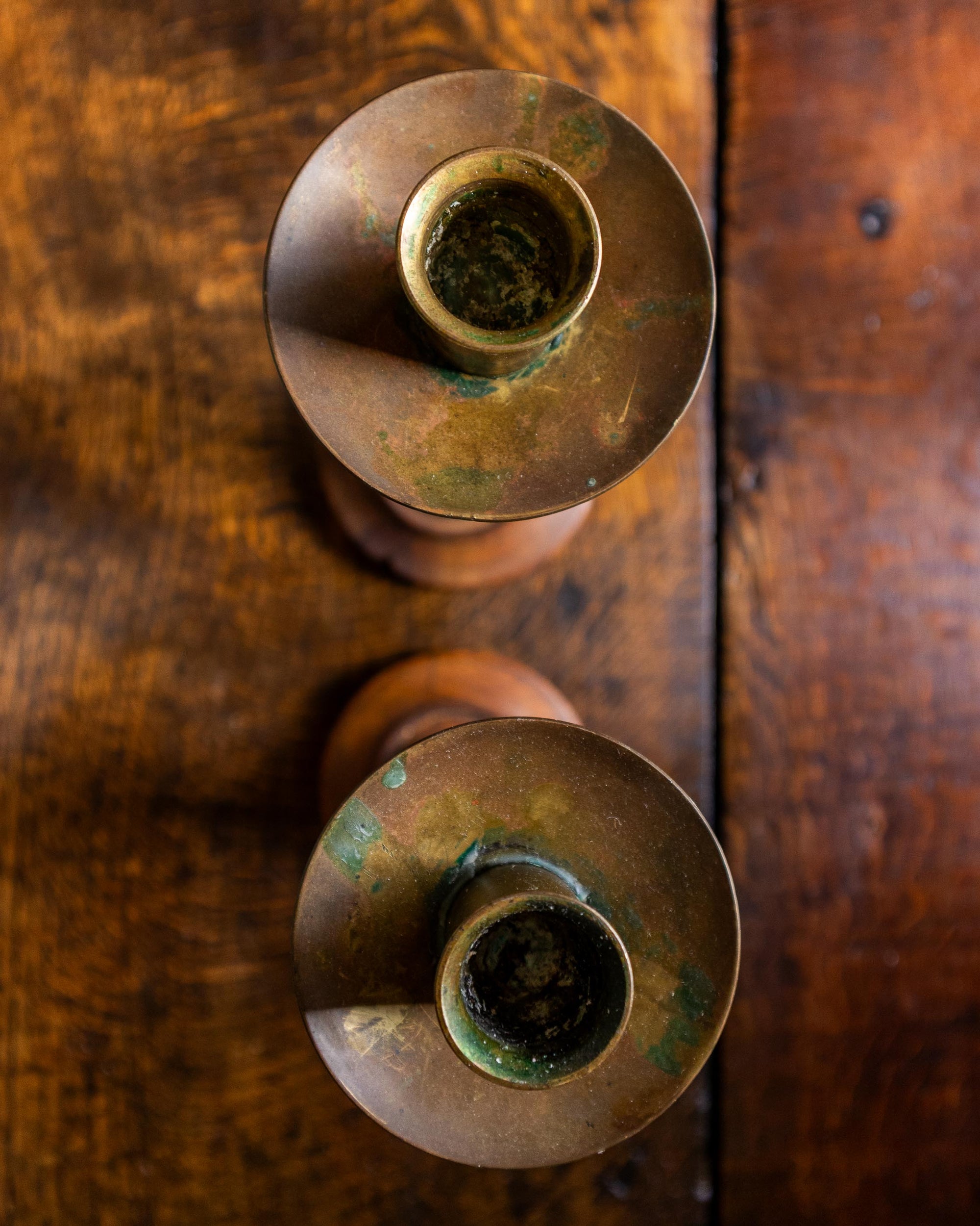 Two oak candle holders on a wooden surface