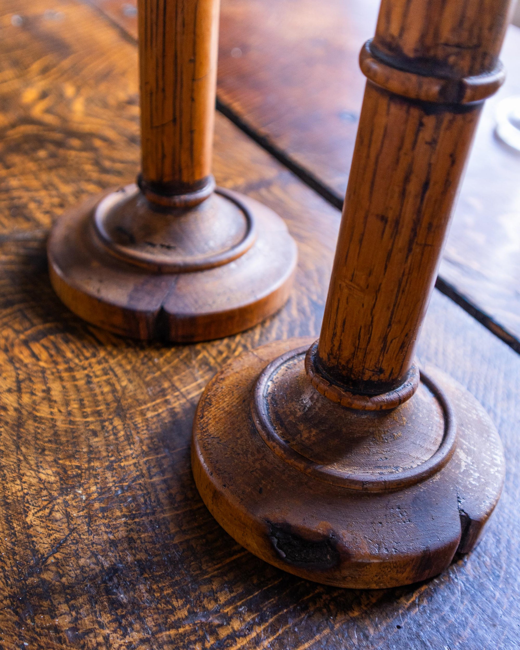Close-up of two wooden candle holders on a rustic wooden surface