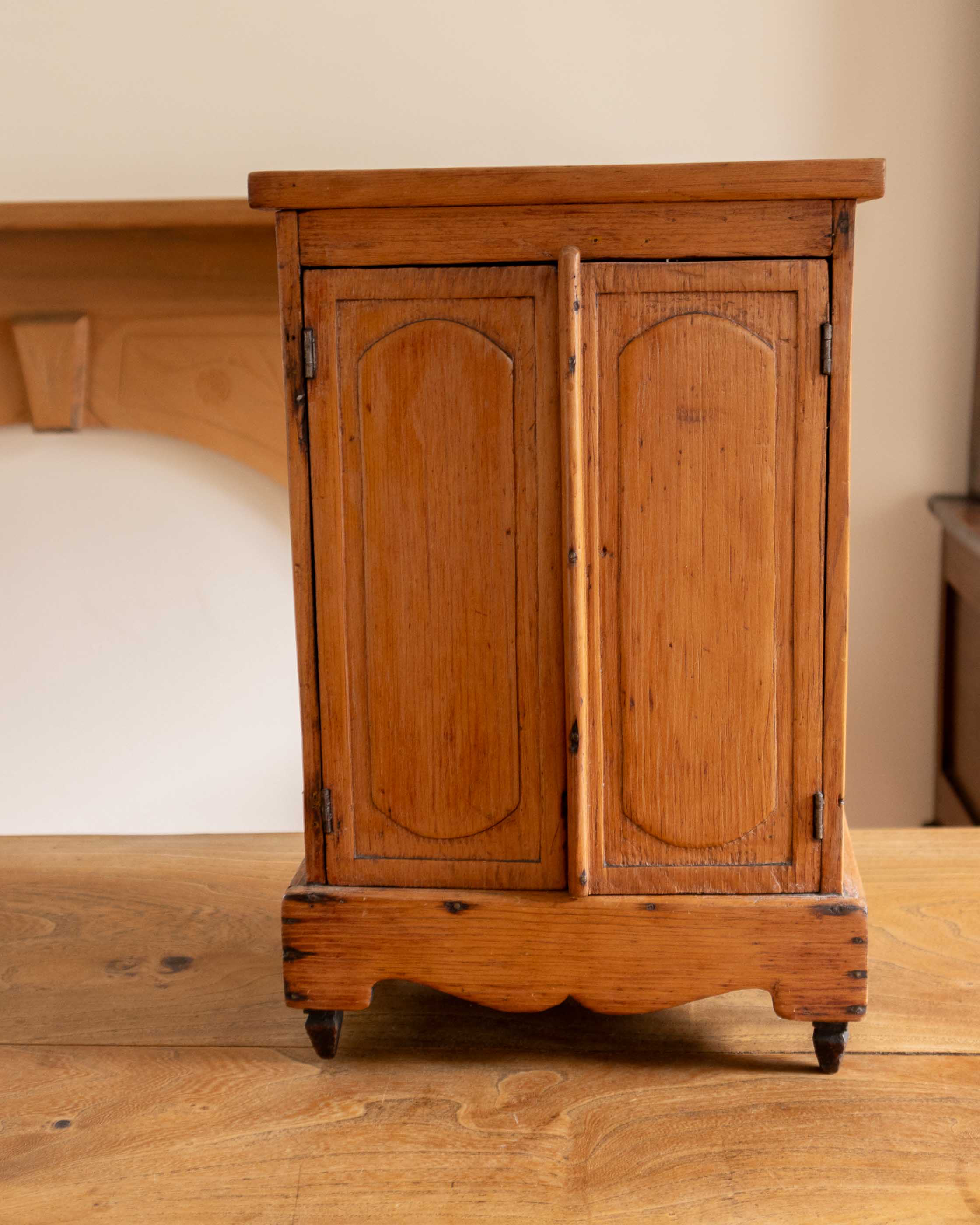 Wooden cabinet with two doors on a wooden floor.