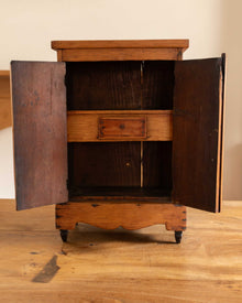 Wooden cabinet with open doors on a wooden floor