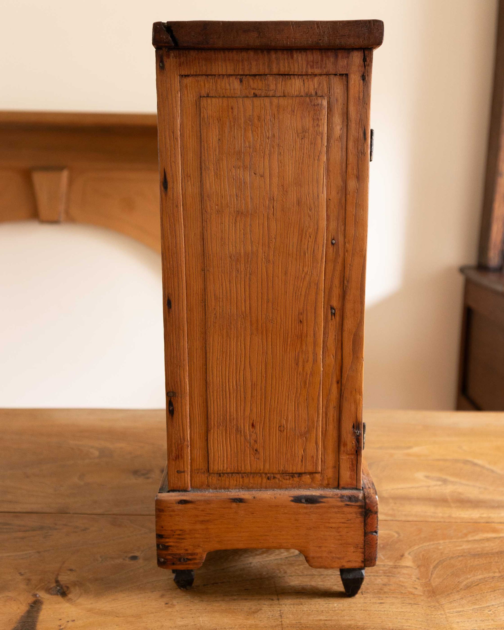 Wooden cabinet on feet with a rustic design in a room setting