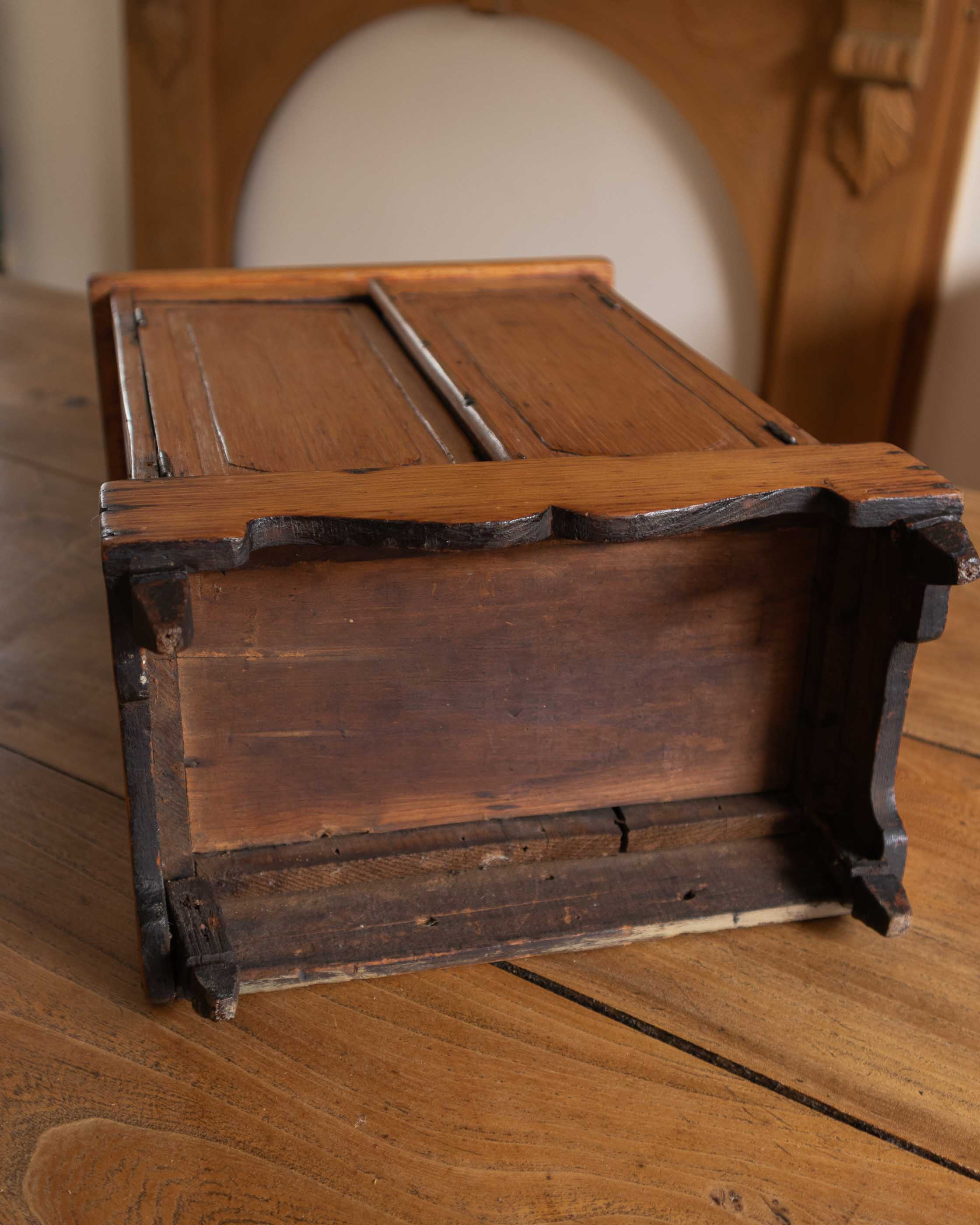 Wooden cabinet with hinged doors on a wooden surface