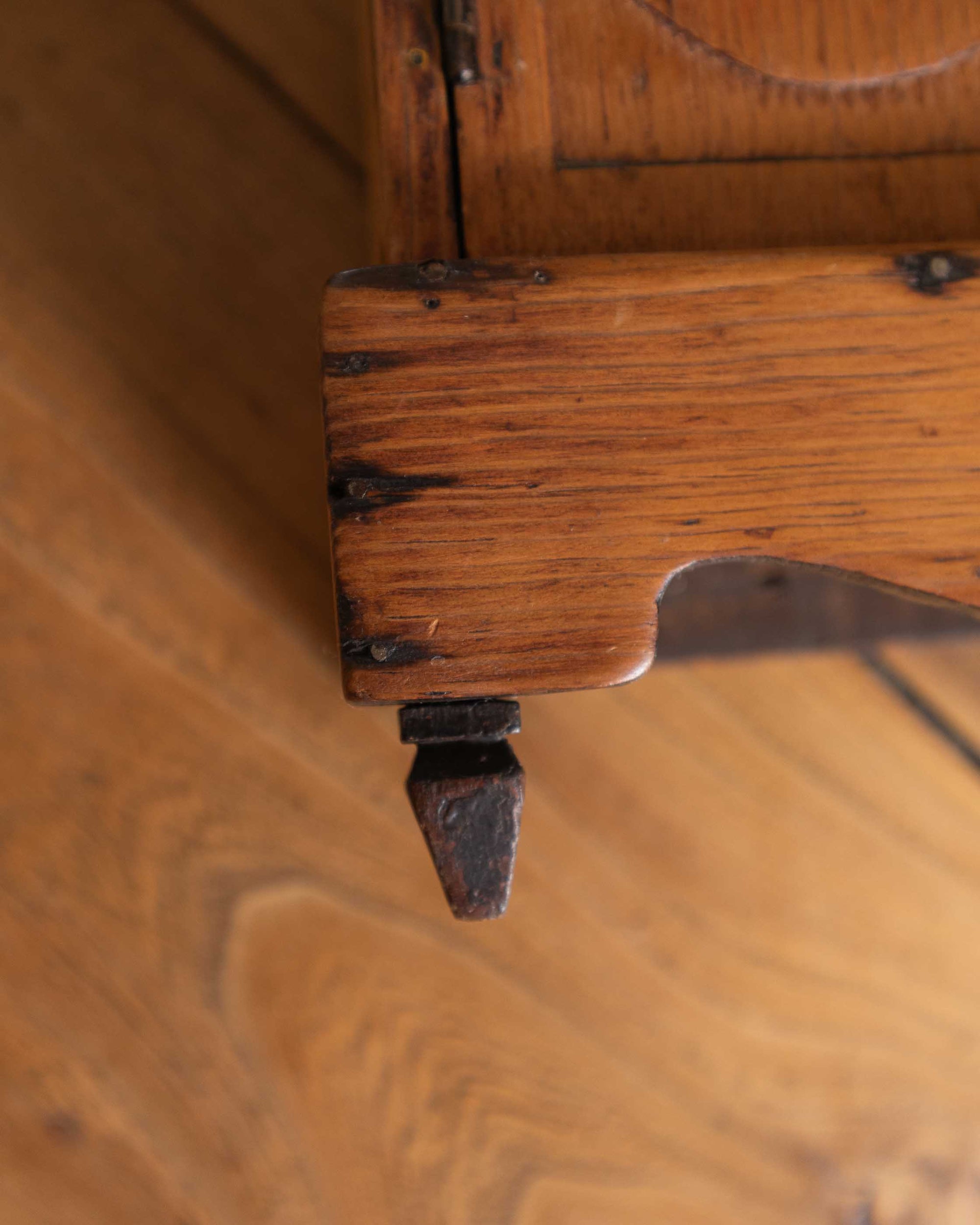 Close-up of a wooden cabinet corner with visible grain and texture.