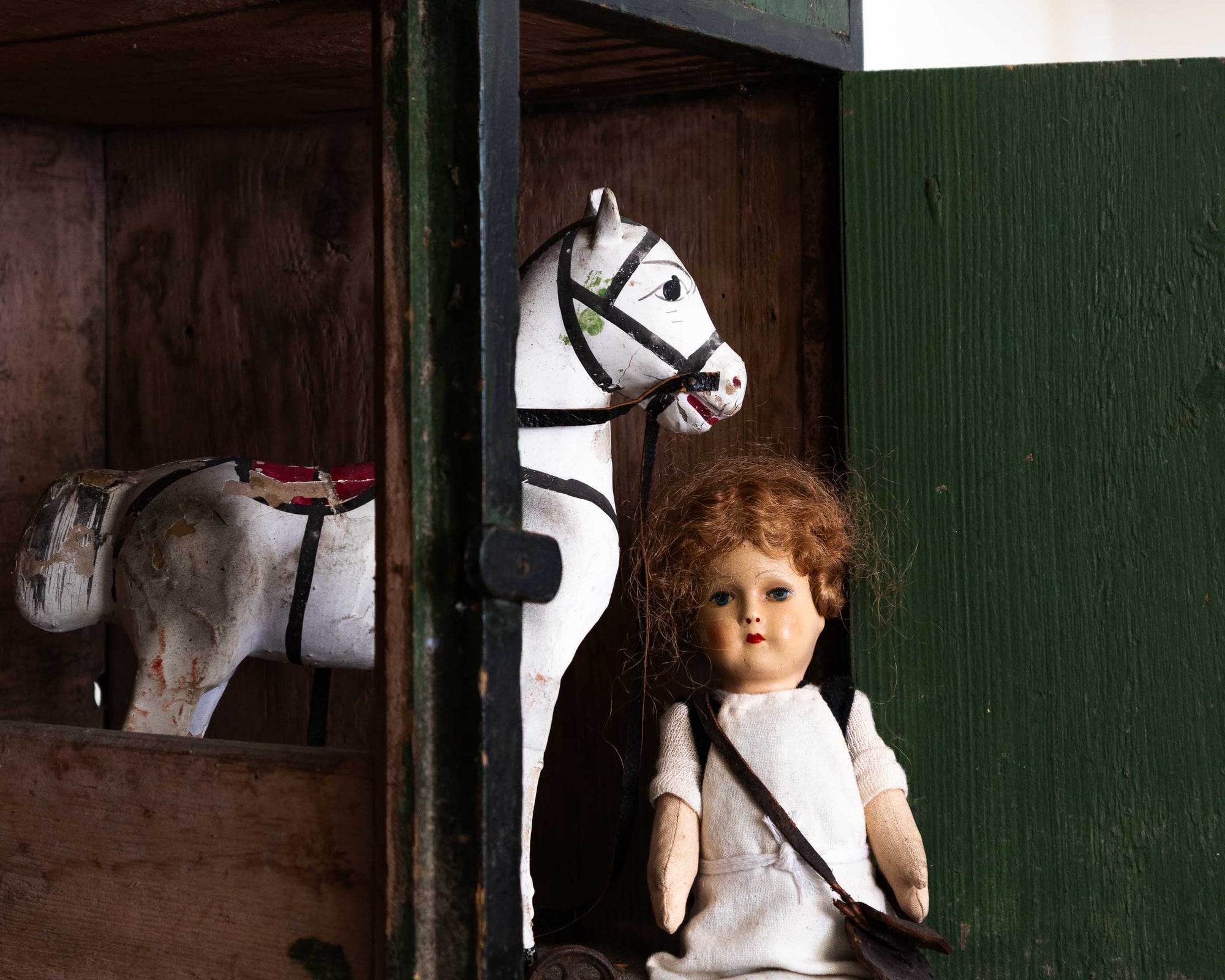 Vintage doll and horse toy in a wooden setting