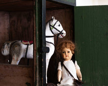 Vintage doll and horse toy in a wooden setting