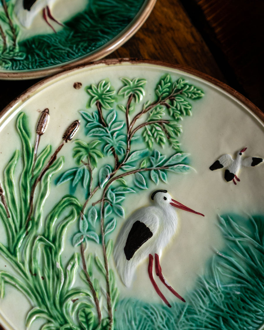 Decorative ceramic plate with bird and plant design on a wooden surface