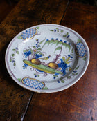 Decorative ceramic plate with floral and fruit design on a wooden surface