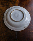White ceramic plate with brown rim on a wooden surface