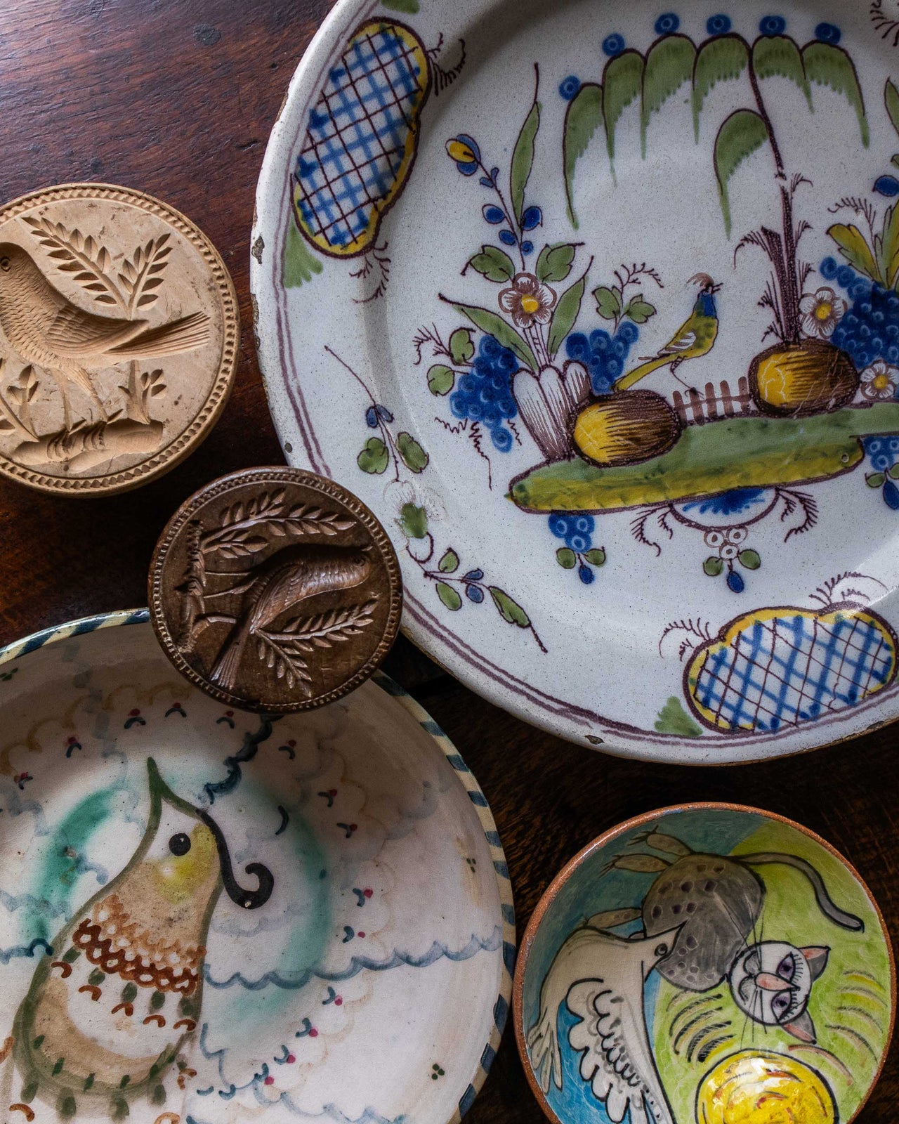 Collection of ceramic plates with decorative designs on a wooden surface