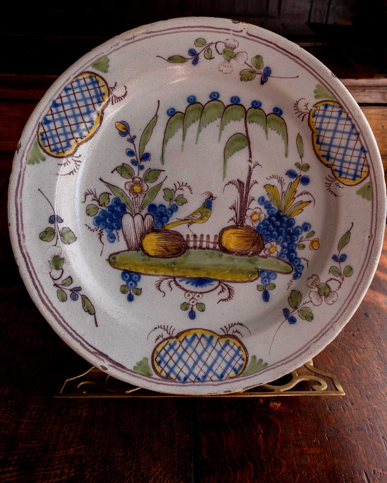 Decorative ceramic plate with floral and bird design on a wooden surface