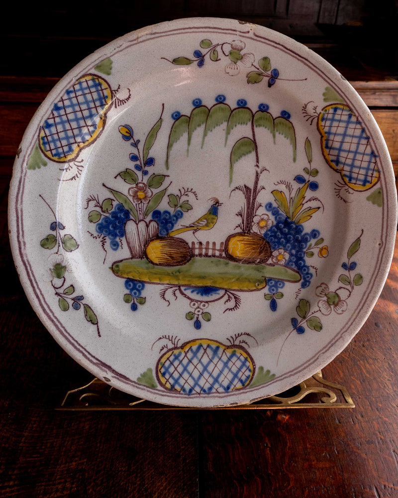 Decorative ceramic plate with floral and bird design on a wooden surface