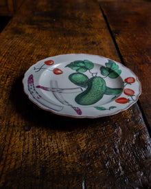 Decorative plate with a cucumber design on a wooden surface