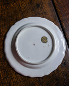 White ceramic plate with a logo on a wooden surface