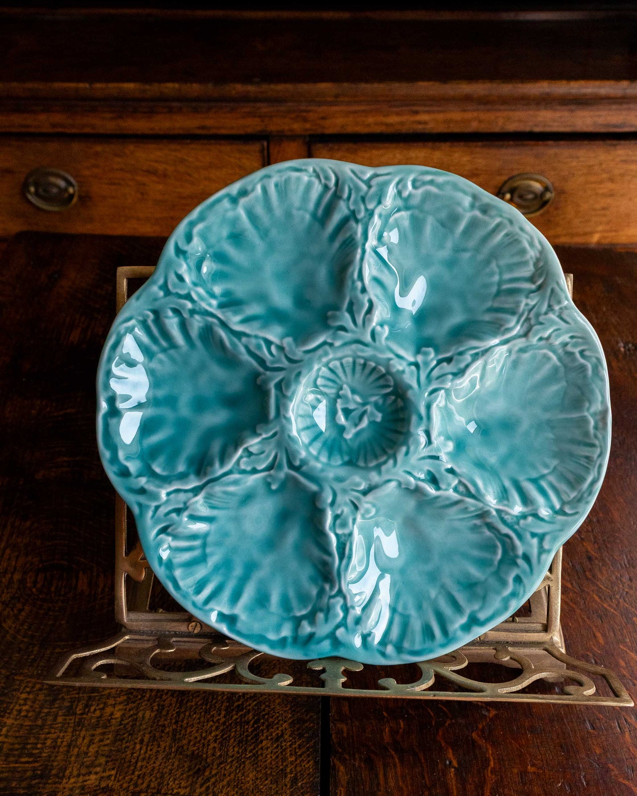Turquoise ceramic plate with shell design on a wooden surface