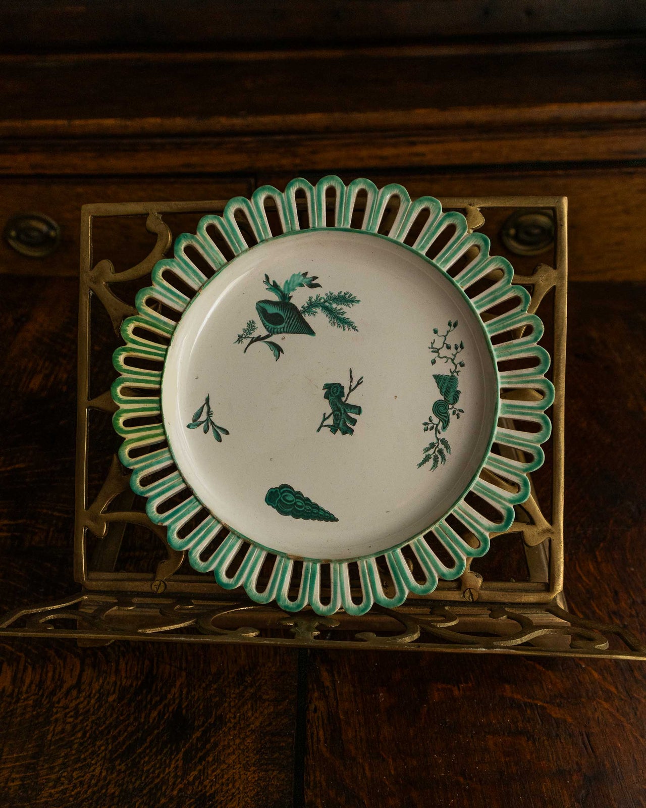Decorative plate with green shell patterns on a wooden surface