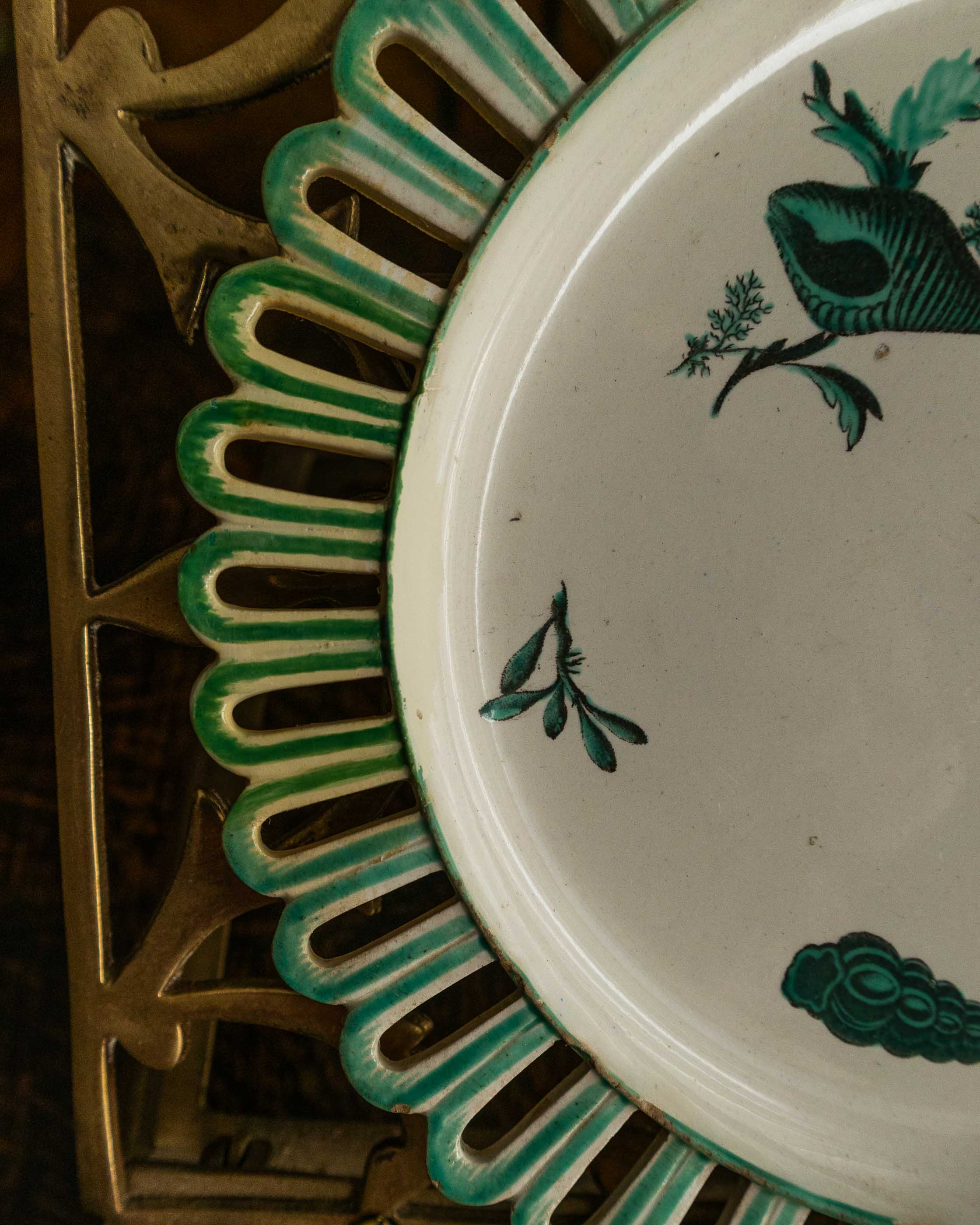 Decorative plate with green shell patterns on a white background, framed by a decorative green border.