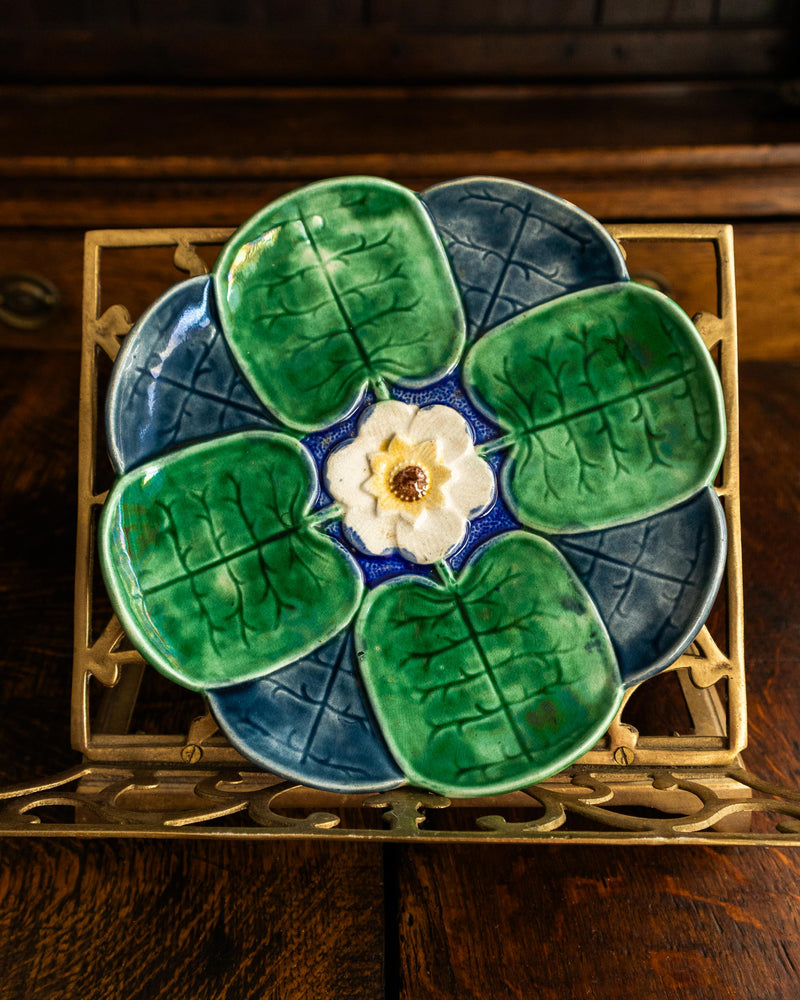 Griffen, Smith & Hill majolica plate with a floral design on a wooden surface