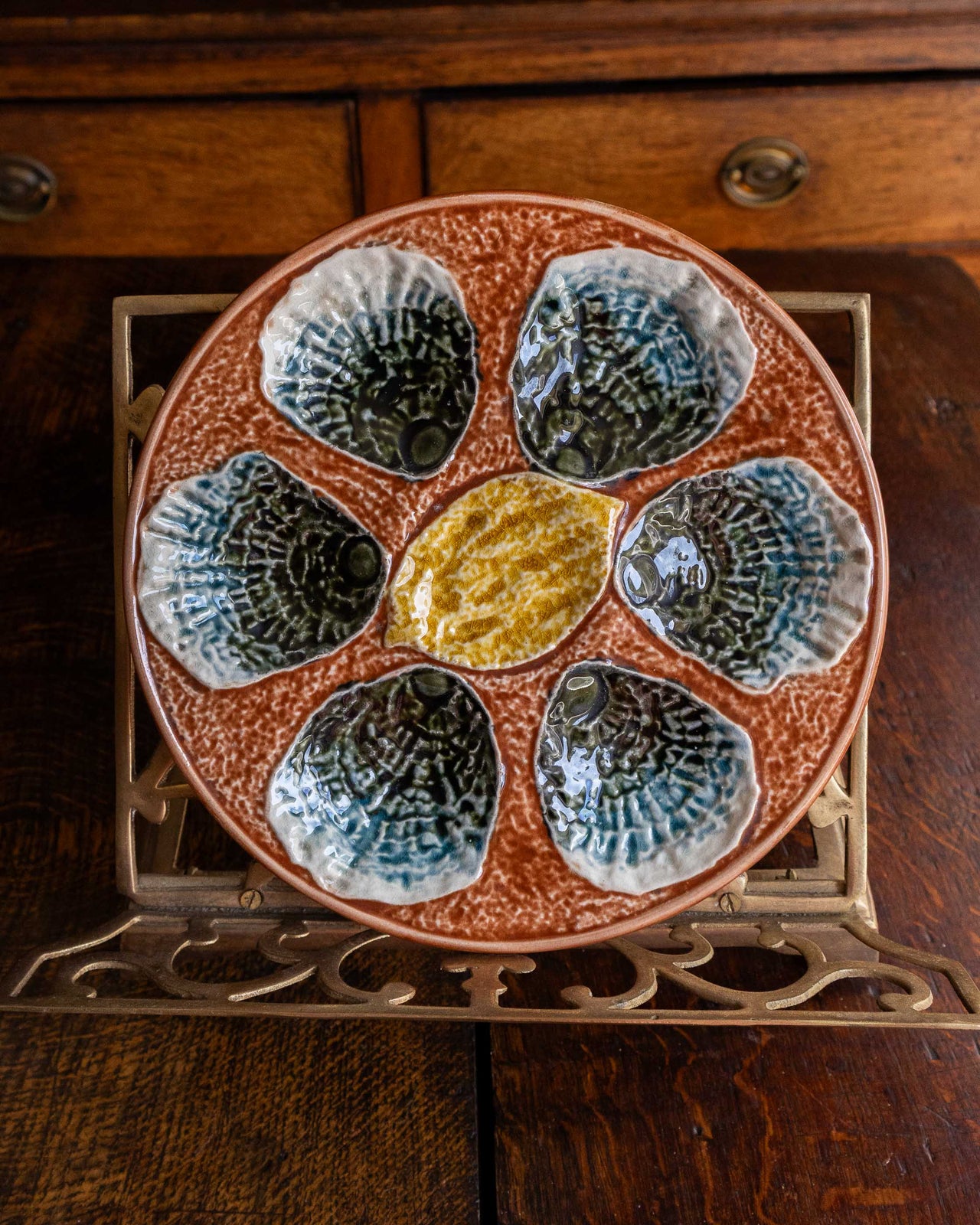 Ceramic majolica oyster plate with shell design on a wooden surface
