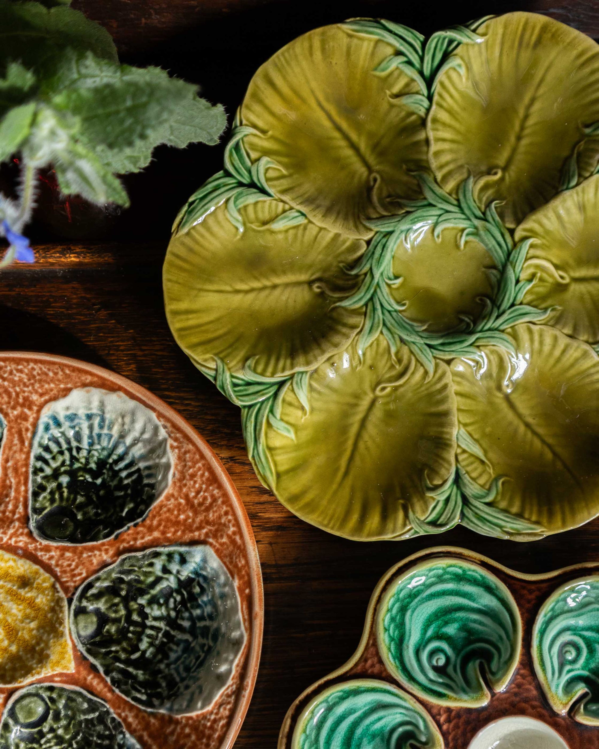 Decorative ceramic oyster plates with leaf patterns on a wooden surface