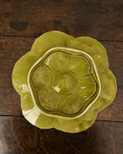 Decorative green oyster plate with green shell patterns on a wooden surface 