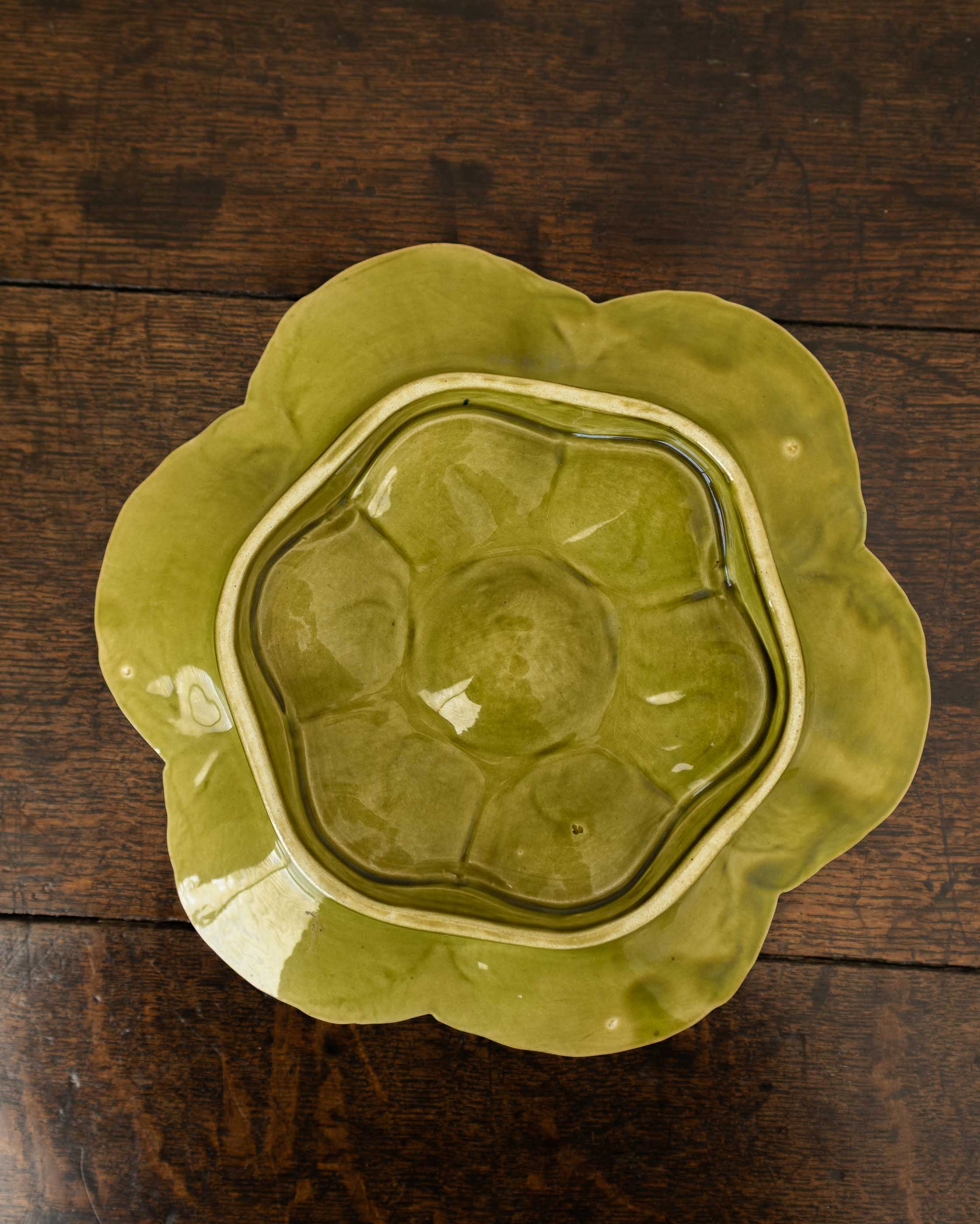 Decorative green oyster plate with green shell patterns on a wooden surface 