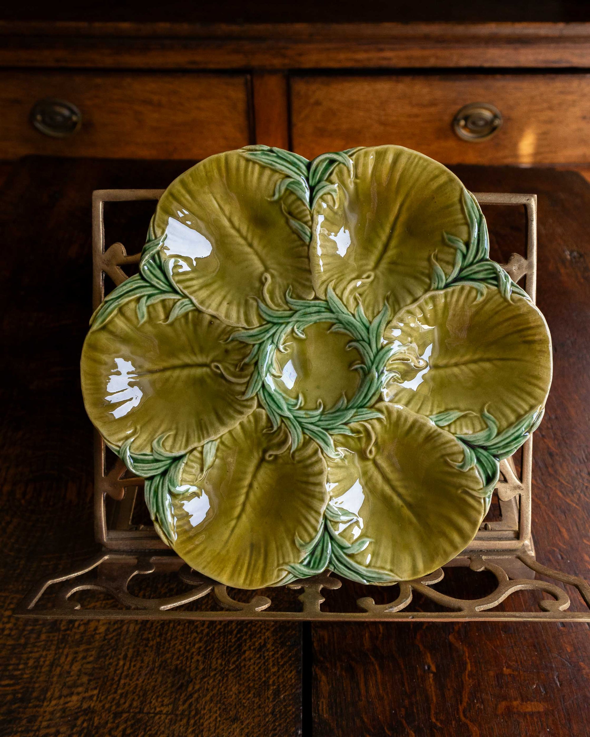 Decorative green oyster plate with green shell patterns on a wooden surface 