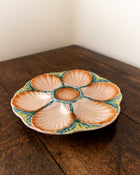 Ceramic oyster plate with shell design on a wooden surface