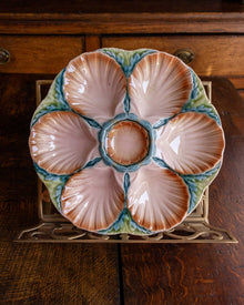 Ceramic oyster plate with shell design on a wooden surface
