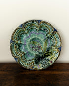 Decorative ceramic plate with floral design on a wooden surface