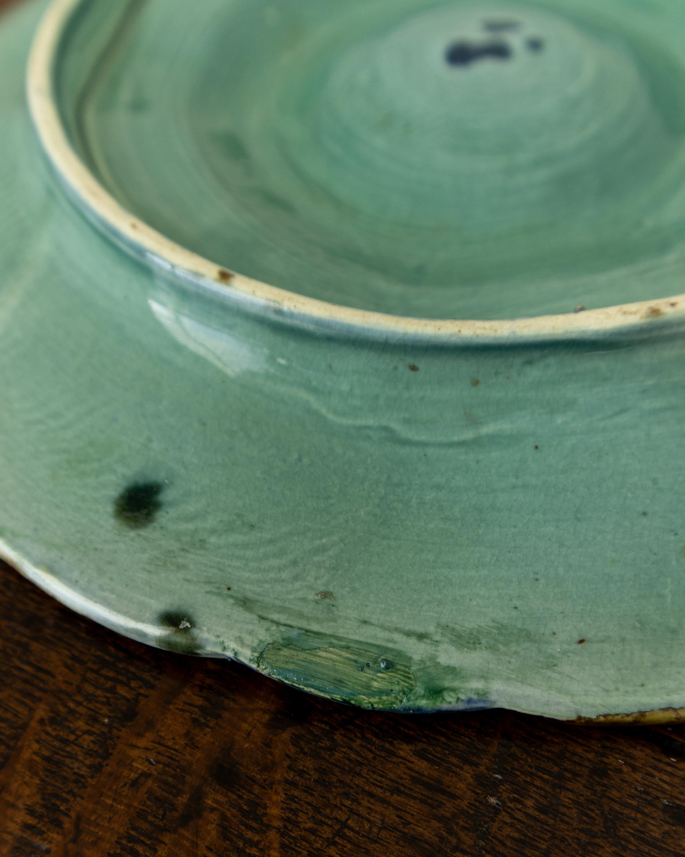 Close-up of a green ceramic plate with visible glaze and texture.
