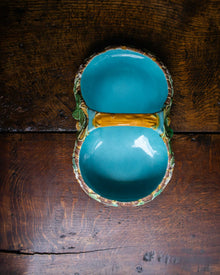 Turquoise ceramic majolica strawberry basket from above on a wooden surface
