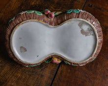 Base of majolica strawberry basket on a wooden surface
