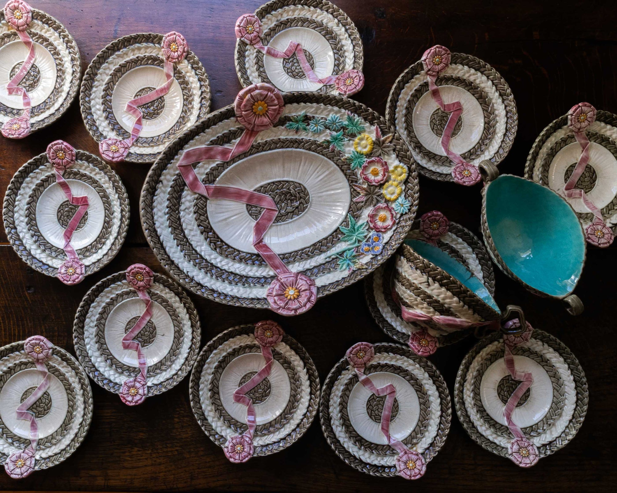 Decorative plates with floral designs and a central plate with a floral arrangement on a wooden surface.