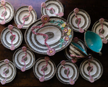 Decorative plates with floral designs and a central plate with a floral arrangement on a wooden surface.