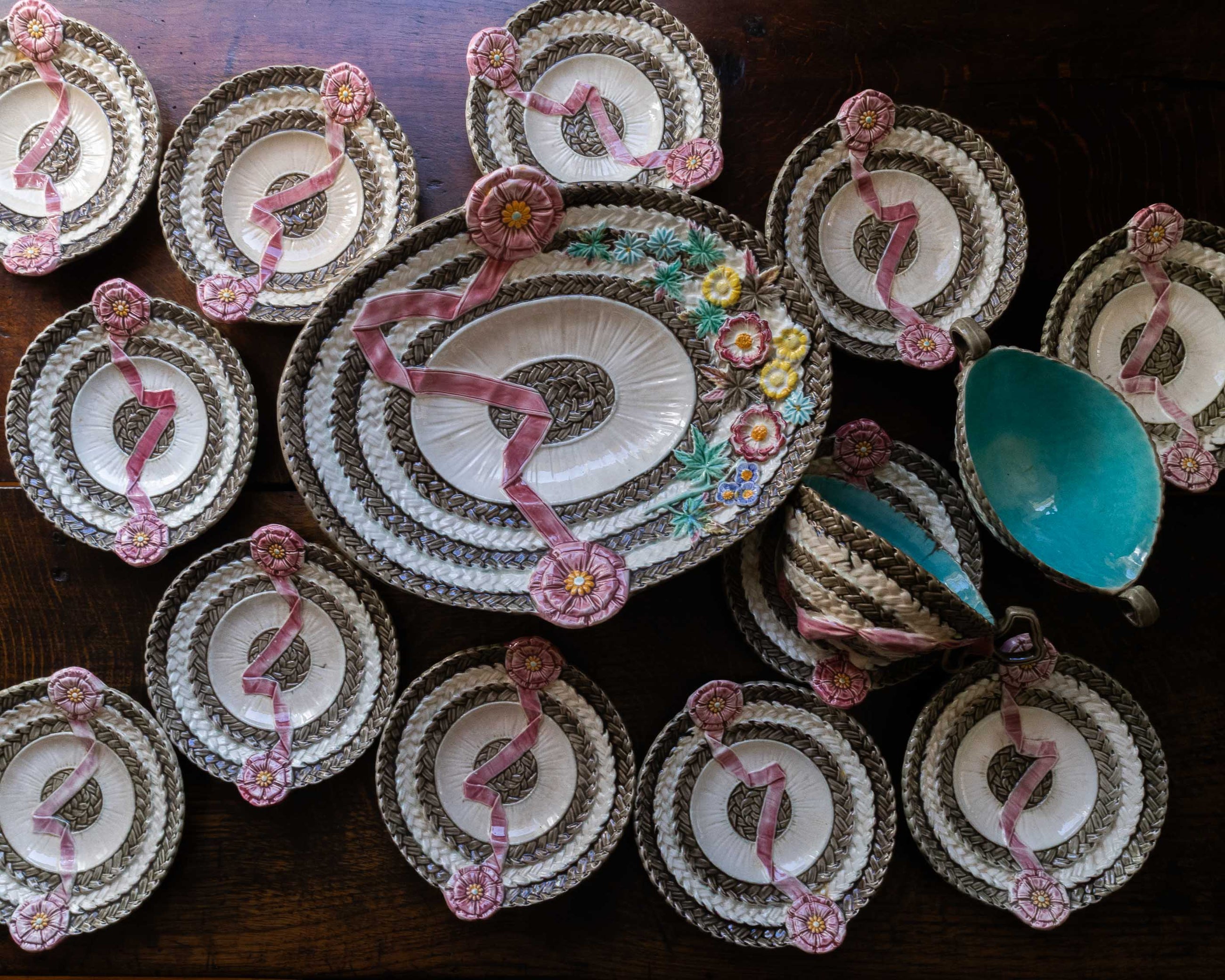 Decorative plates with floral designs and a central plate with a floral arrangement on a wooden surface.