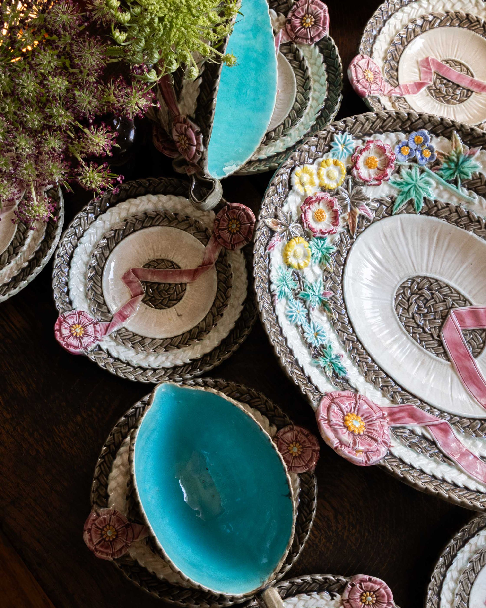 Decorative plates with floral embroidery and blue centers on a wooden surface.