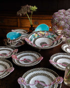 Decorative plates with floral designs and ribbons on a wooden surface.