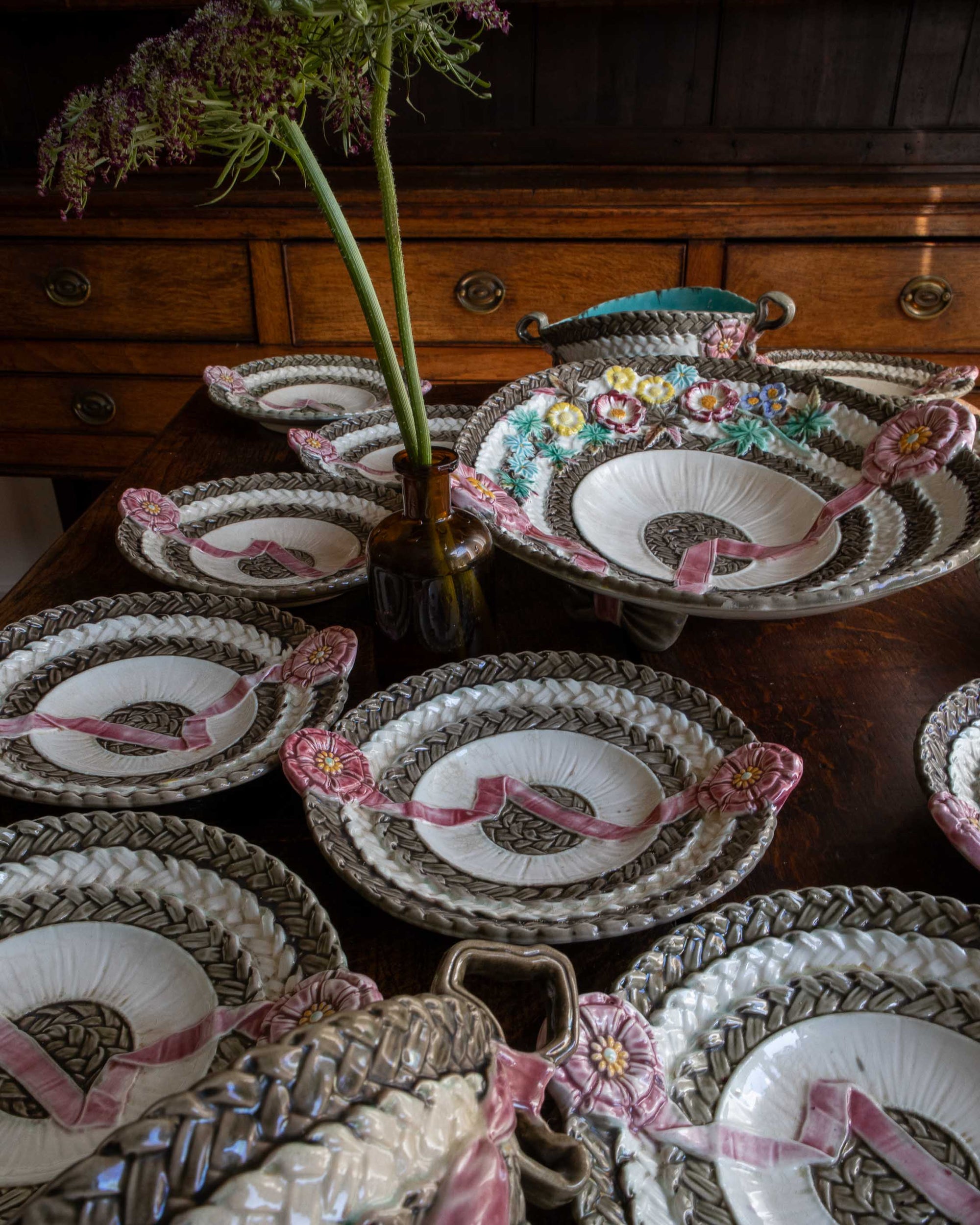 Decorative plates with floral and ribbon designs on a wooden surface.