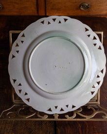 White decorative plate with cut-out patterns on a wooden surface