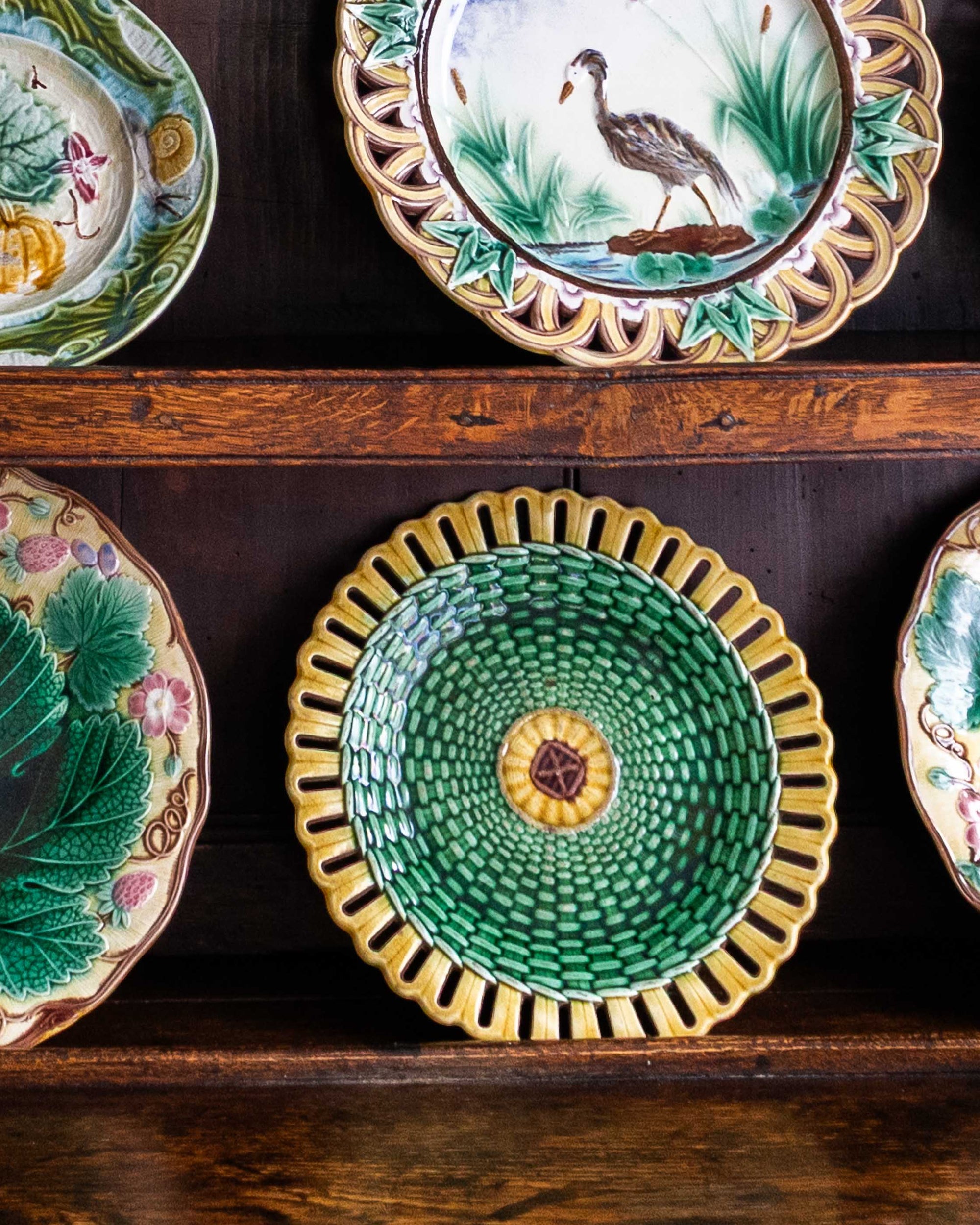 Collection of decorative ceramic plates on a wooden shelf