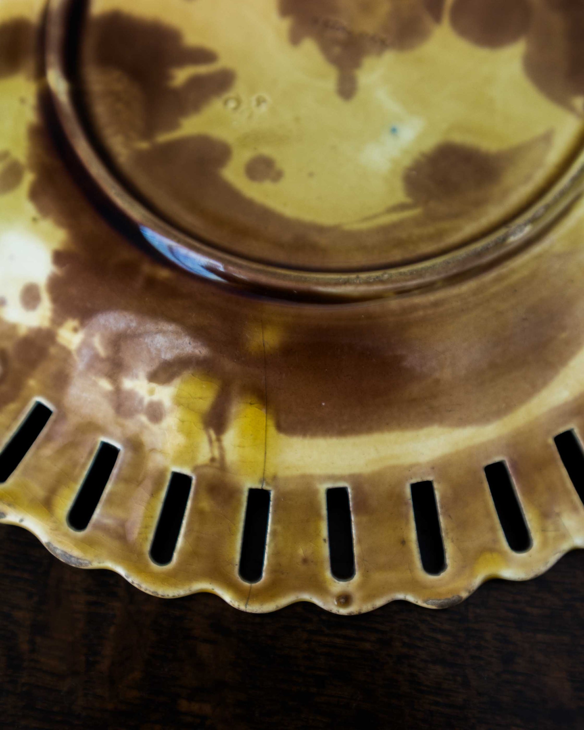 Close-up of a ceramic plate with a scalloped edge and central circular design.